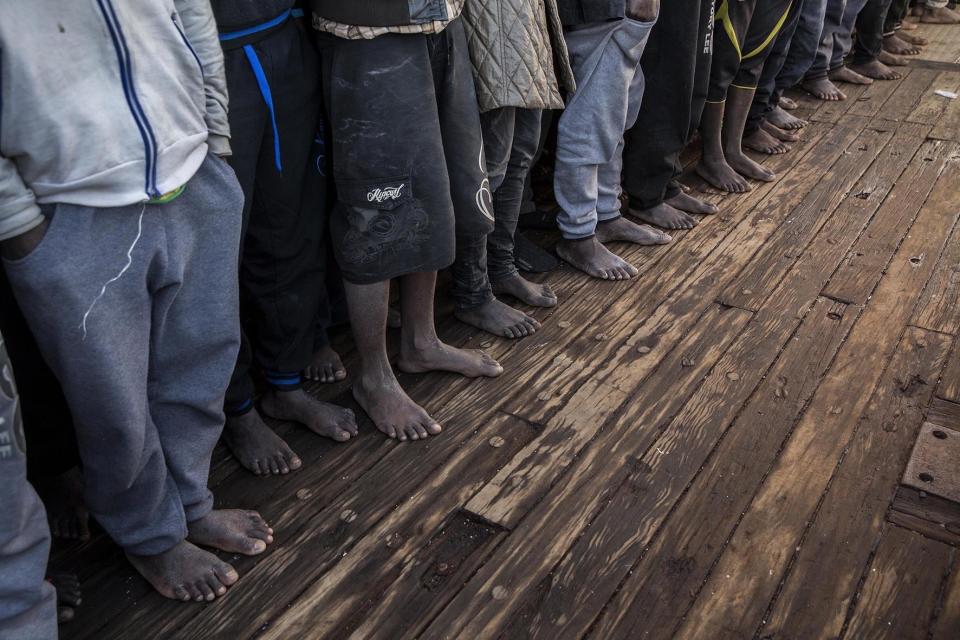 In this Saturday Jan. 14, 2017 photo, migrants from Mali stand at the deck of the Golfo Azzurro vessel after being rescued from the Mediterranean sea, about 20 miles north of Ra's Tajura, Libya. Spain's maritime rescue service says the bodies of seven African migrants have been found dead along the Strait of Gibraltar since Friday. (AP Photo/Olmo Calvo)