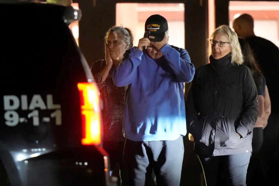 People depart a reunification center early Thursday at Auburn Middle School, in Auburn, Maine.