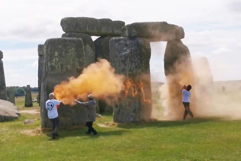 Screen grab taken from handout video of Just Stop Oil protesters spraying an orange substance on Stonehenge (PA Media)