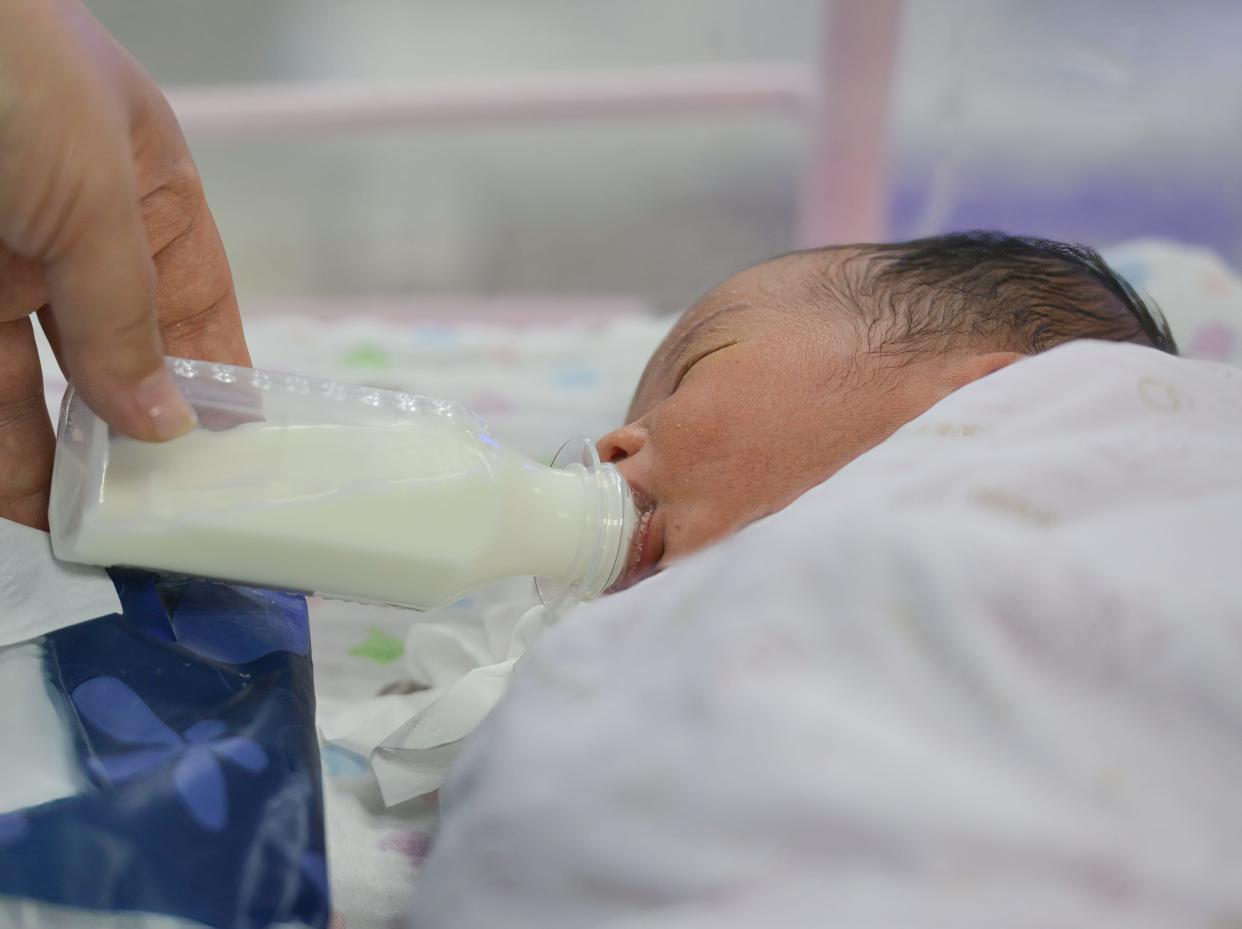 A newborn baby is seen being fed on a bottle in the ward of a hospital in China