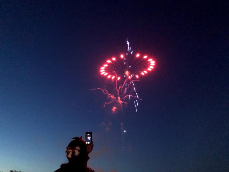 A woman takes a video of a Canada Day fireworks display in Guelph in 2018.