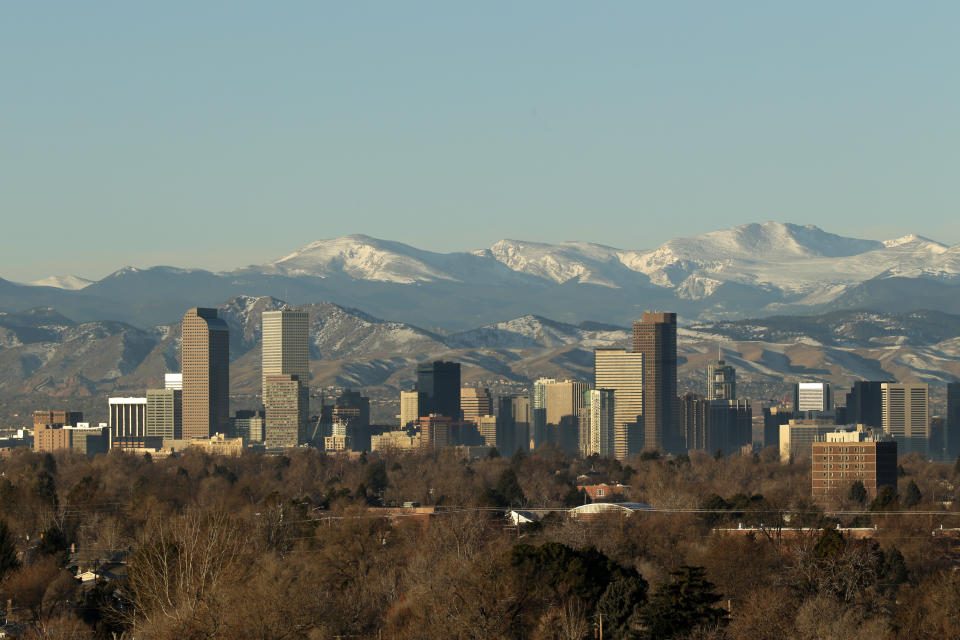 The Rocky Mountains rise beyond Denver skyline Sunday, Jan. 24, 2016. (AP Photo/Charlie Riedel)