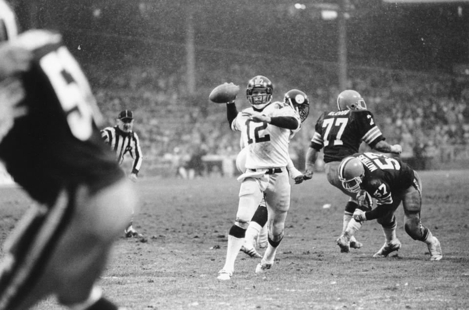 Pittsburgh Steelers quarterback Terry Bradshaw (12) winds up to pass in the fourth quarter after eluding Cleveland Browns rushers Lyle Alzado (77) and Clay Matthews (57) at Cleveland Stadium, Ohio, on Nov. 22, 1981.  Bradshaws pass was complete to Rick Moser in the end zone for the Steelers' final touchdown in their 32-10 romp over the Browns.  (AP Photo/Mastroianni)