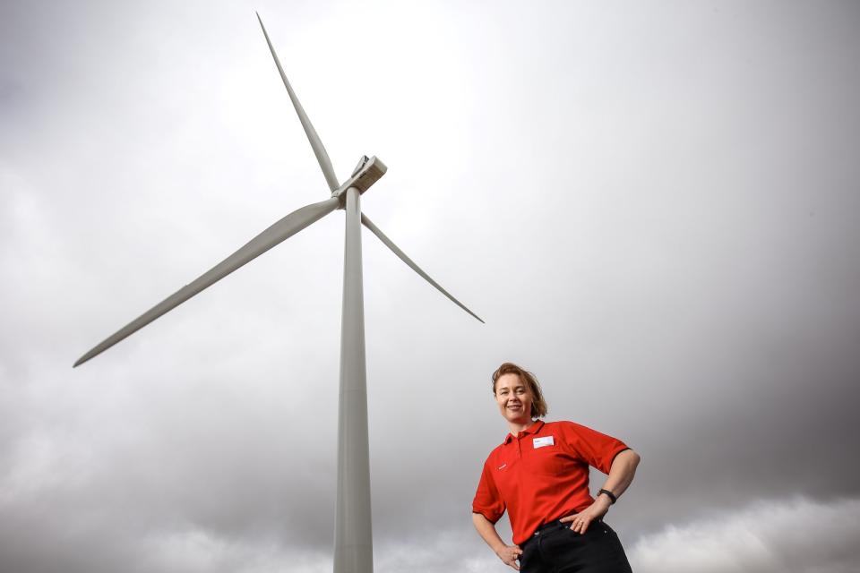 Coles employee stands under wind turbine. Source: Coles Group