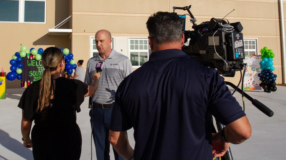 Dart Meyers, Principal at South Pointe Elementary School, talks to a TV reporter before the start of Friday's first classes of the year. South Pointe is one of two new public schools in Polk County.