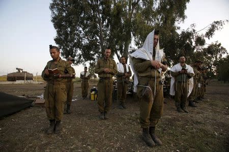 Israeli soldiers pray close to the ceasefire line between Israel and Syria on the Golan Heights, in this May 7, 2013 file photo. REUTERS/Baz Ratner/Files