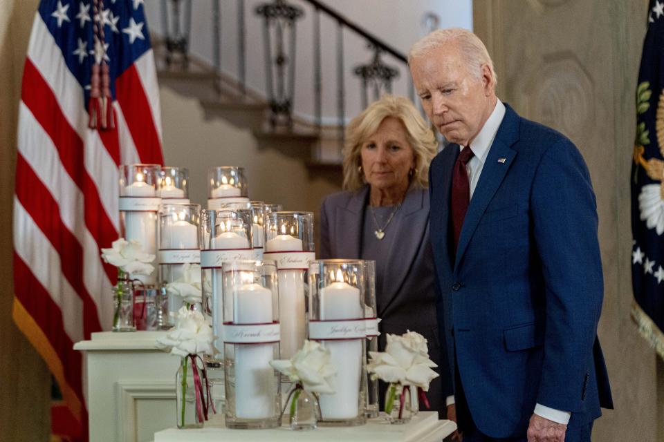 President Joe Biden, accompanied by first lady Jill Biden, looks at flowers and candles with the names of victims as he arrives to speak on the one year anniversary of the school shooting in Uvalde, Texas, at the White House in Washington, Wednesday, May 24, 2023. (AP Photo/Andrew Harnik)