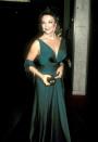 <p>Joan Collins in a rich jewel toned Grecian-inspired gown.</p>