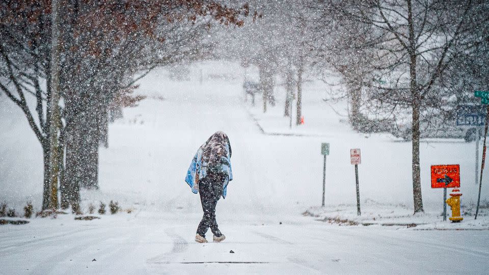 A person crosses Tennessee Street as snow falls Monday in downtown Florence, Alabama. - Dan Busey/The TimesDaily/AP