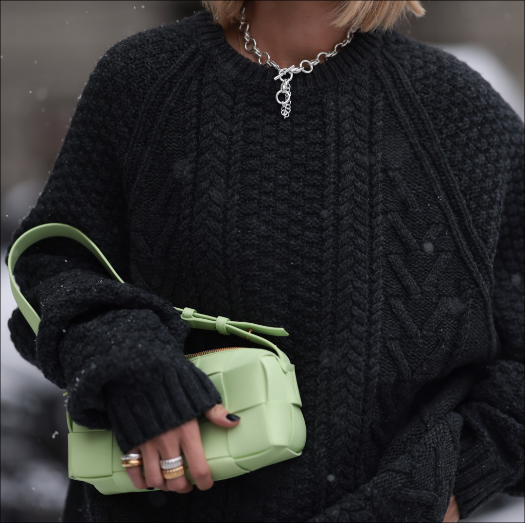  Nadine Berneis seen wearing Black Palms the label black wool cable knit sweater, silver earrings, Glambou silver chain necklace, Bottega Veneta light green / pastel green leather bag, on November 29, 2023 in Berlin, Germany. . 