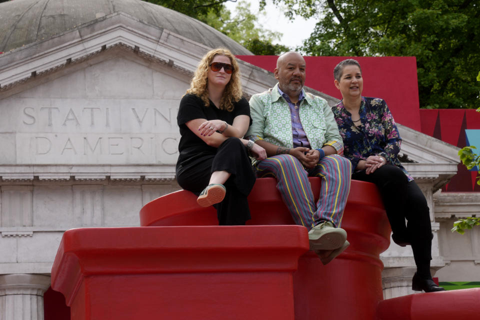 La curadora Abigail Winograd, de izquierda a derecha, el artista Jeffrey Gibson, y la curadora Curator Kathleen Ash-Milby posan en el pabellón estadounidense en un recorrido para medios en la 60a Bienal de Artes en Venecia, Italia, el martes 16 de abril de 2024. Gibson, un choctaw de Mississippi de ascendencia cherokee, es el primer indígena estadounidense en representar a Estados Unidos en solitario en la Bienal de Venecia, la muestra de arte contemporáneo más antigua del mundo. (Foto AP/Luca Bruno)