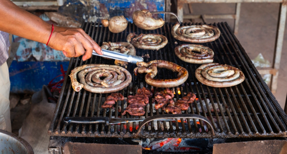 Coils of dog meat are barbecued over hot coals. 