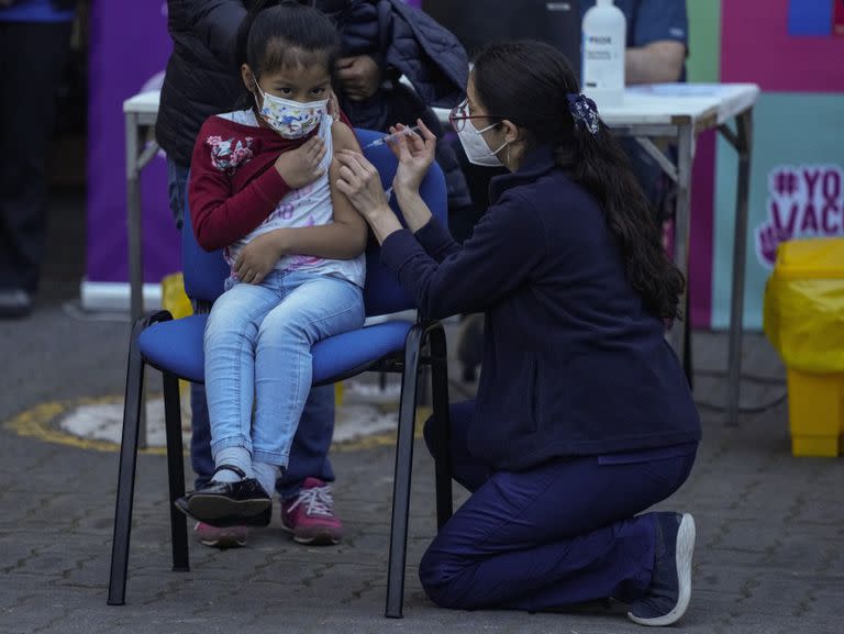 Un trabajador de la salud inocula a una niña contra el COVID-19 en la escuela Providencia en Santiago, Chile, el lunes 27 de septiembre de 2021, durante el inicio de la vacunación en escuelas para niños de 6 a 11 años. 