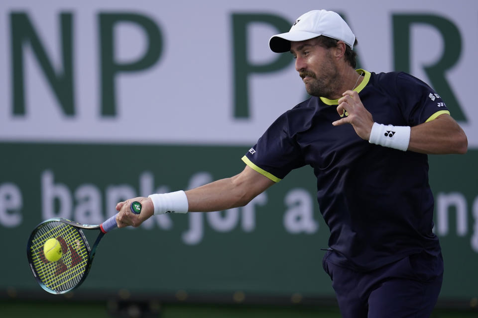 Steve Johnson returns a shot against Hubert Hurkacz, of Poland, at the BNP Paribas Open tennis tournament Tuesday, March 15, 2022, in Indian Wells, Calif. (AP Photo/Marcio Jose Sanchez)