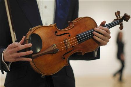 Violist David Aaron Carpenter of the U.S. holds the 'Macdonald' Viola by Antonio Stradivari, made in 1719, at Sotheby's gallery in New York March 27, 2014. REUTERS/Eduardo Munoz