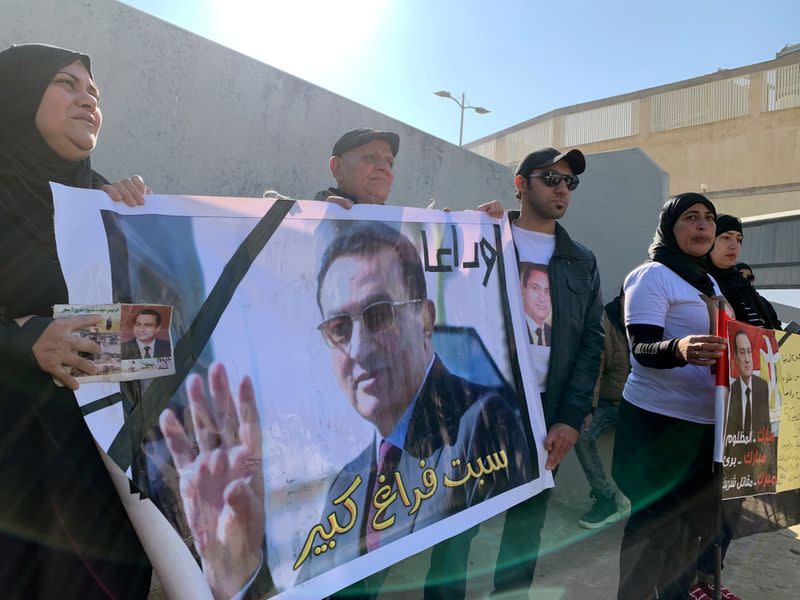 Supporters of former Egyptian President Hosni Mubarak wait before the funeral in Cairo