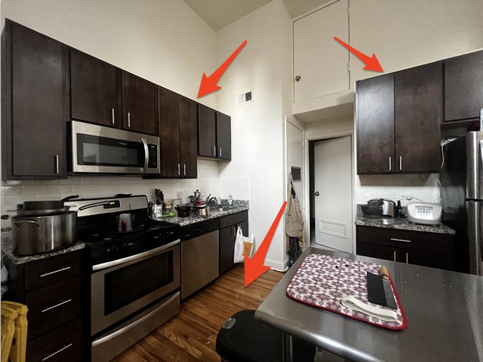 Small kitchen with dark brown cabinets and metal island table.