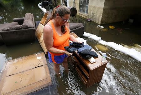 Amber James wrings out her clothes while standing in flood water in St. Amant, Louisiana, U.S., August 20, 2016. REUTERS/Jonathan Bachman