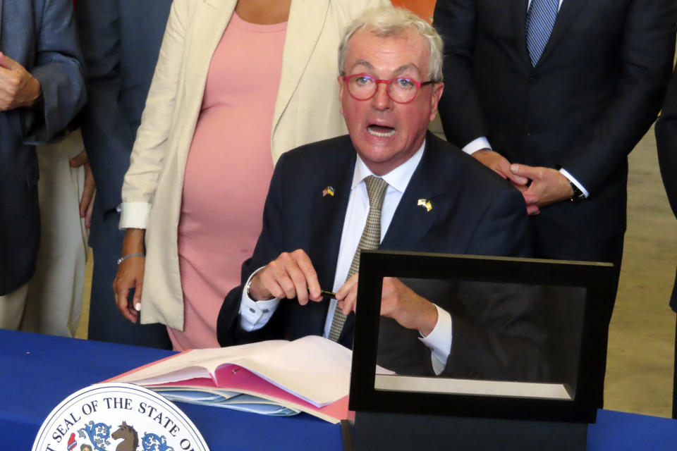 New Jersey Gov. Phil Murphy signs a bill in Paulsboro, N.J., Thursday, July 6, 2023, granting a tax break to offshore wind energy developer Orsted. (AP Photo/Wayne Parry)