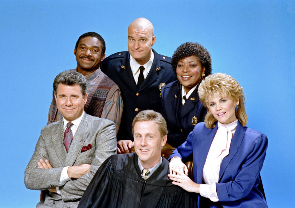 NIGHT COURT — SEASON 4 Pictured: (clockwise from top center) Richard Moll as Nostradamus “Bull” Shannon, Marsha Warfield as Rosalind ‘Roz’ Russell, Markie Post as Christine Sullivan, Harry Anderson as Judge Harold “Harry” T. Stone, John Larroquette as Daniel R. “Dan” Fielding, Charles Robinson as Macintosh “Mac” Robinson — (Photo by: NBC via Getty Images)