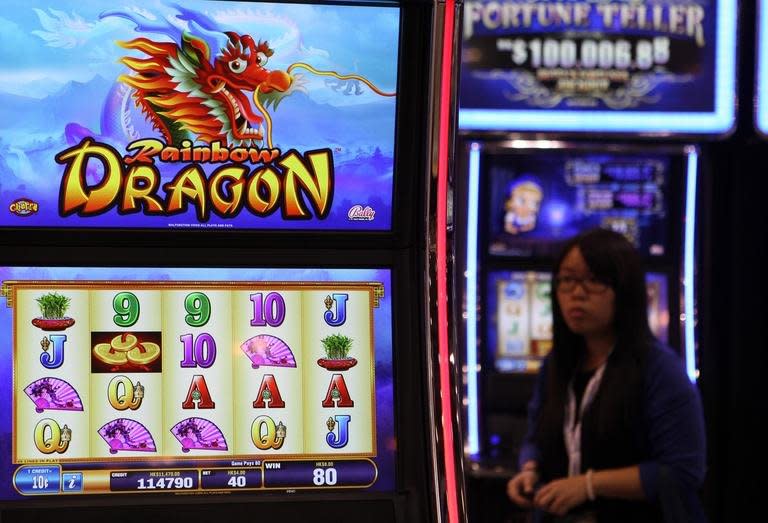 A woman walks past gaming machines at the G2E Asia gaming expo in Macau on May 22, 2012. The casino industry is booming across Asia, offering anyone looking for high-stakes action a wide choice of venues, from high-tech South Korea to the Himalayan nation of Nepal and communist Vietnam