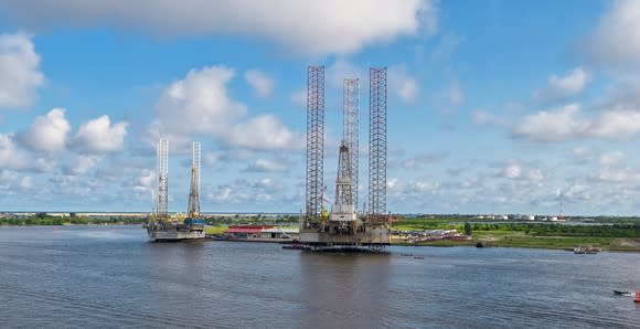 Offshore drilling rigs sitting idle in a shipyard.