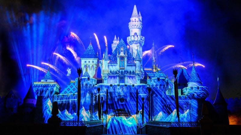 Sleeping Beauty Castle with the Blue Fairy flying over projections from Wish
