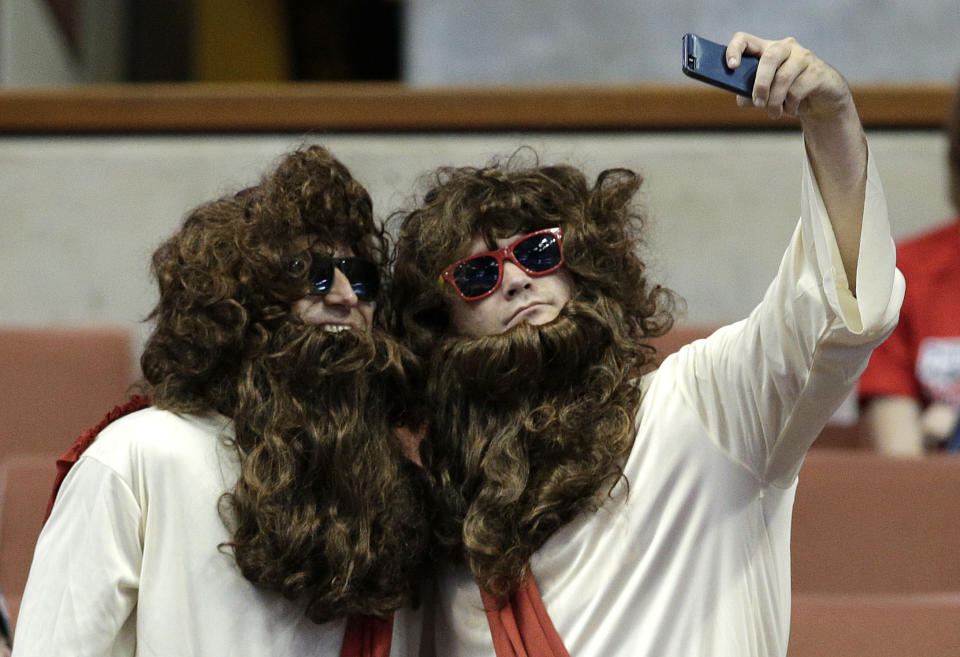 Wisconsin fans take pictures with their phones prior to a regional semifinal NCAA college basketball tournament game between Baylor and Wisconsin, Thursday, March 27, 2014, in Anaheim, Calif. (AP Photo/Jae C. Hong)