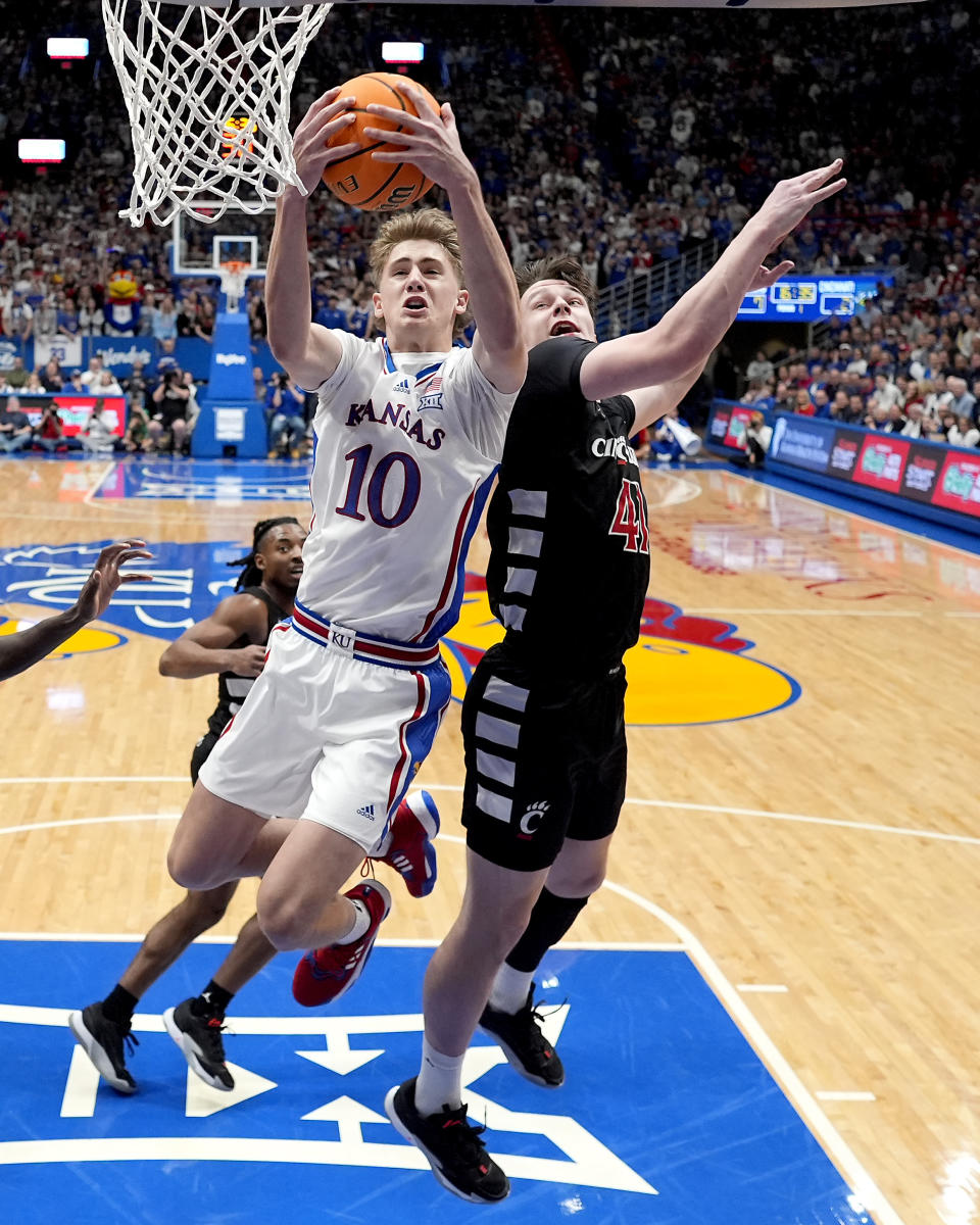 Kansas guard Johnny Furphy, left, beats Cincinnati guard Simas Lukosius (41) to a rebound during the first half of an NCAA college basketball game Monday, Jan. 22, 2024, in Lawrence, Kan. (AP Photo/Charlie Riedel)