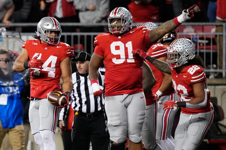 Nov 18, 2023; Columbus, Ohio, USA; Ohio State Buckeyes linebacker Steele Chambers (22) and defensive tackle Tyleik Williams (91) celebrate an interception by defensive end JT Tuimoloau (44) during the NCAA football game against the Minnesota Golden Gophers at Ohio Stadium.