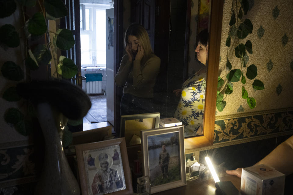 Anastasiia Okhrimenko stands in front of a picture of her late husband, Yurii Stiahliuk, at his parent's apartment in Bucha, Ukraine, Tuesday, Jan. 31, 2023. As the conflict that killed her loved one still rages on, Anastasiia wrestles with a question that all of war-torn Ukraine must grapple with: After loss, what comes next? (AP Photo/Daniel Cole)
