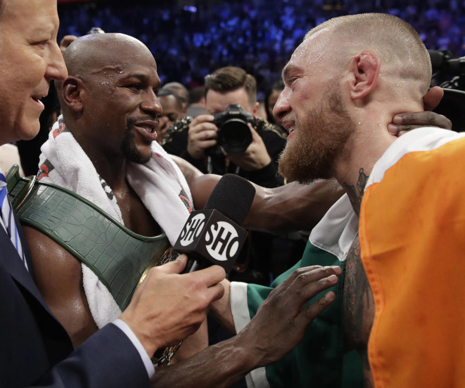 Floyd Mayweather Jr., left, speaks with Conor McGregor after a super welterweight boxing match Saturday, Aug. 26, 2017, in Las Vegas. (AP)