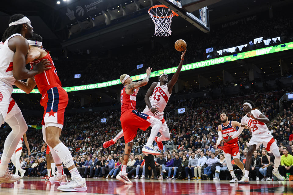 Toronto Raptors forward Pascal Siakam (43) shoots around Washington Wizards forward Kyle Kuzma, center left, during second-half NBA basketball game action in Toronto, Monday, Nov. 13, 2023. (Christopher Katsarov/The Canadian Press via AP)