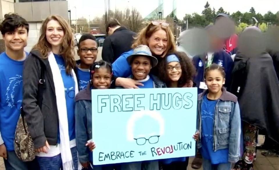 The Hart Family stands for a photo, holding a sign that says "Free Hugs"
