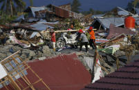 In this Friday, Oct. 5, 2018, photo, men carry a salvaged motorbike from the Petobo neighborhood wiped out by liquefaction caused by a massive earthquake in Palu, Central Sulawesi, Indonesia. Many in the decimated village had no idea they were in an area already identified as a high-risk zone for this apocalyptic phenomenon that causes soft ground to liquefy during temblors. The area around Sulawesi island's Palu Bay had been slammed before and was due for another potential perfect storm, capable of unleashing earthquakes, landslides, tsunami waves, and soil liquefaction. (AP Photo/Dita Alangkara)