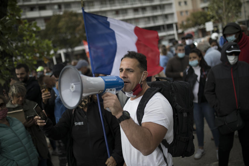 Restaurant owners demonstrate outside the gates of La Timone public hospital as French Health Minister Olivier Veran visits in Marseille, southern France, Friday Sept. 25, 2020. Angry restaurant and bar owners are demonstrating in Marseille to challenge a French government order to close all public venues as of Saturday to battle resurgent virus infections. The government argues that hospitals in this Mediterranean city are under strain and the closures are the only way to stem the spread while avoiding new lockdowns. (AP Photo/Daniel Cole)