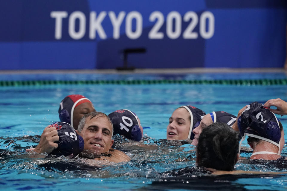 FILE - United States head coach Adam Krikorian hugs Paige Hauschild (5) after defeating Spain in the women's water polo gold medal match at the 2020 Summer Olympics, Saturday, Aug. 7, 2021, in Tokyo, Japan. With the Paris Olympics coming up next year, U.S. women's water polo coach Adam Krikorian is feeling the pressure of time. No water polo team — men or women — has won four straight gold medals at the Games. (AP Photo/Mark Humphrey, File)