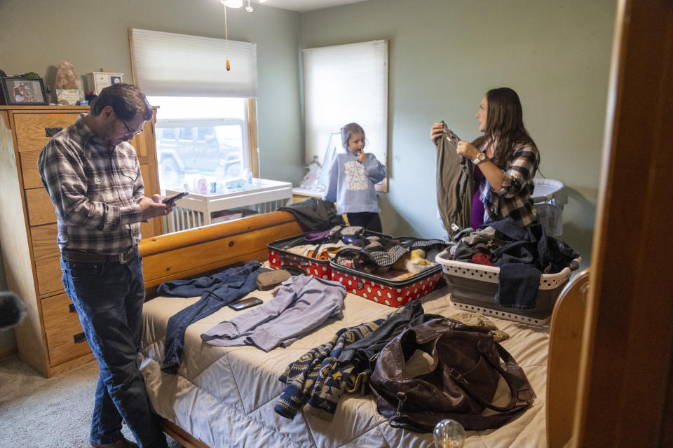 Shane Alderson, his wife, Alisha, and their daughter, Adeline, 5, pack for a trip to Idaho at the family's home in Baker City, Ore., on Friday, Sept. 1, 2023. Because of the closing of Baker City's only obstetrical unit, the family is traveling to the Boise, Idaho area, a little over 100 miles away, to give birth. (AP Photo/Kyle Green)