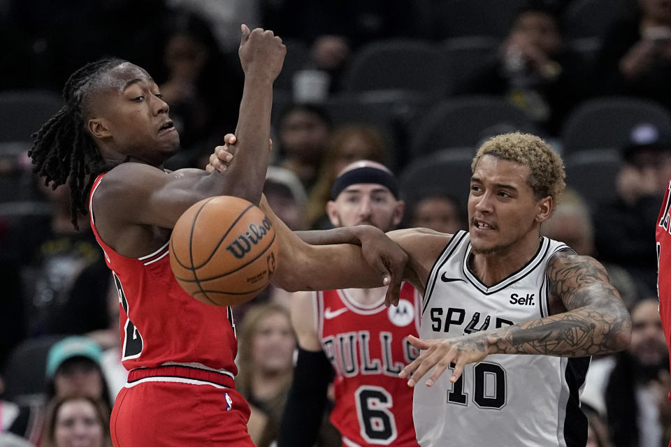 Chicago Bulls guard Ayo Dosunmu (12) and San Antonio Spurs forward Jeremy Sochan (10) battle for a rebound during the second half of an NBA basketball game in San Antonio, Saturday, Jan. 13, 2024. (AP Photo/Eric Gay)