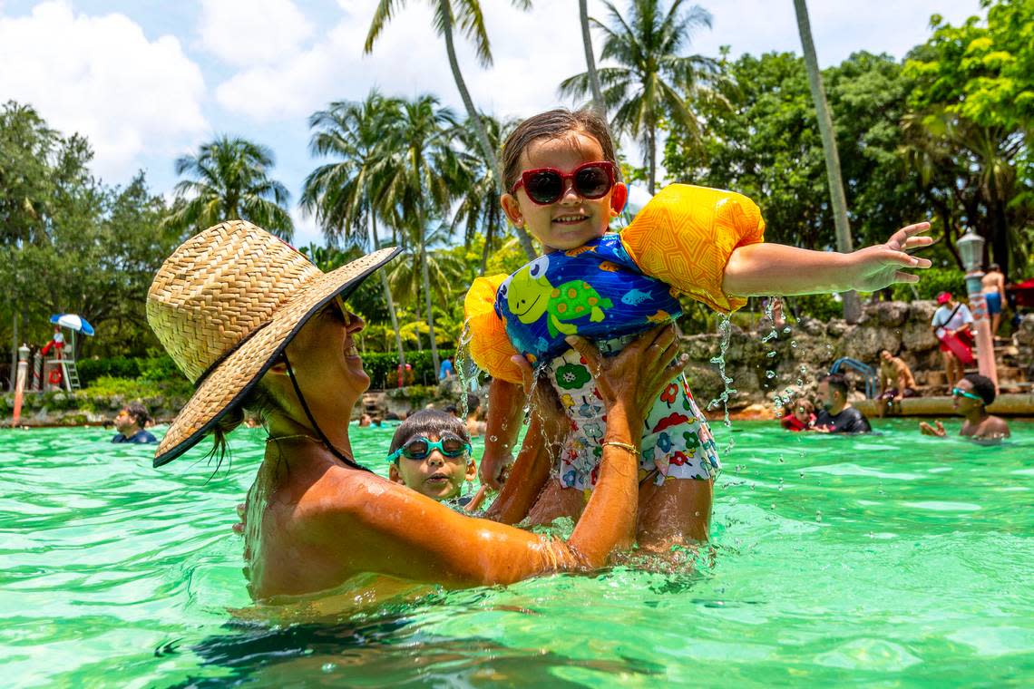 Palmetto Bay resident Claudia Lemus, 41, holds up her daughter Emma, 4, as her son Evan, 8, swims in the background at Venetian Pool on June 28, 2023, in Coral Gables. A temperature of 95 degrees was recorded at the Miami International Airport that day.