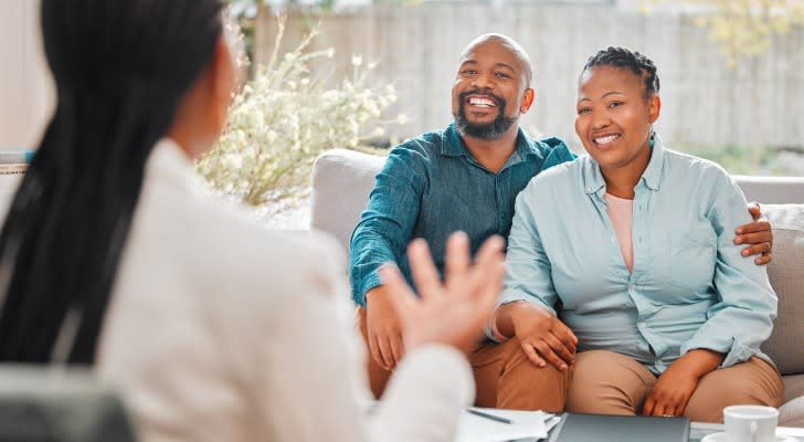 A middle-age couple meets with their financial advisor about retiring early.