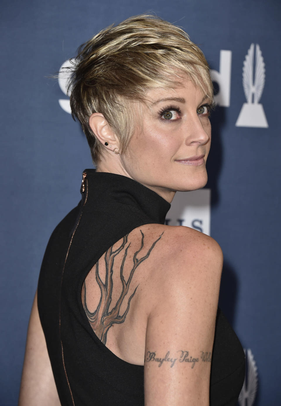 Teri Polo in a black ensemble showing off her back tattoos 