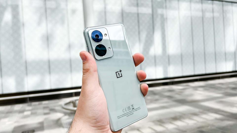 The OnePlus Nord 2T, held in hand with the back facing the camera