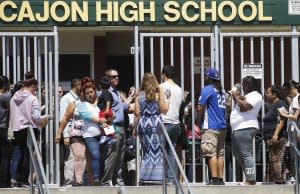 Parents and guardians of North Park Elementary School students wait on Monday at Cajon High School to be reunited with their children in San Bernardino, California.