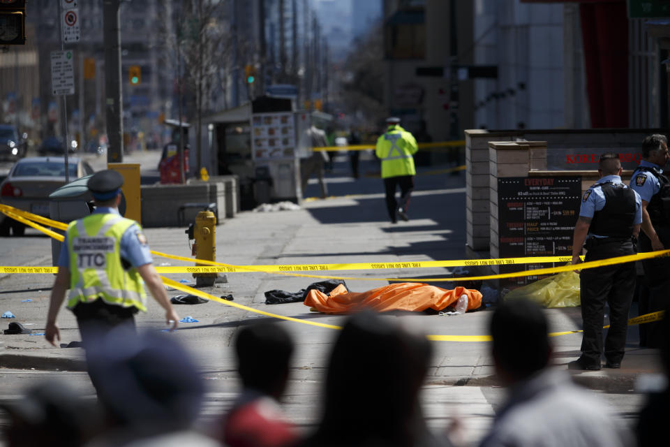 <p>A tarp lays on top of a body on Yonge St. at Finch Ave. after a van plowed into pedestrians on April 23, 2018 in Toronto, Canada. A suspect is in custody after a white van collided with multiple pedestrians. (Photo: Cole Burston/Getty Images) </p>