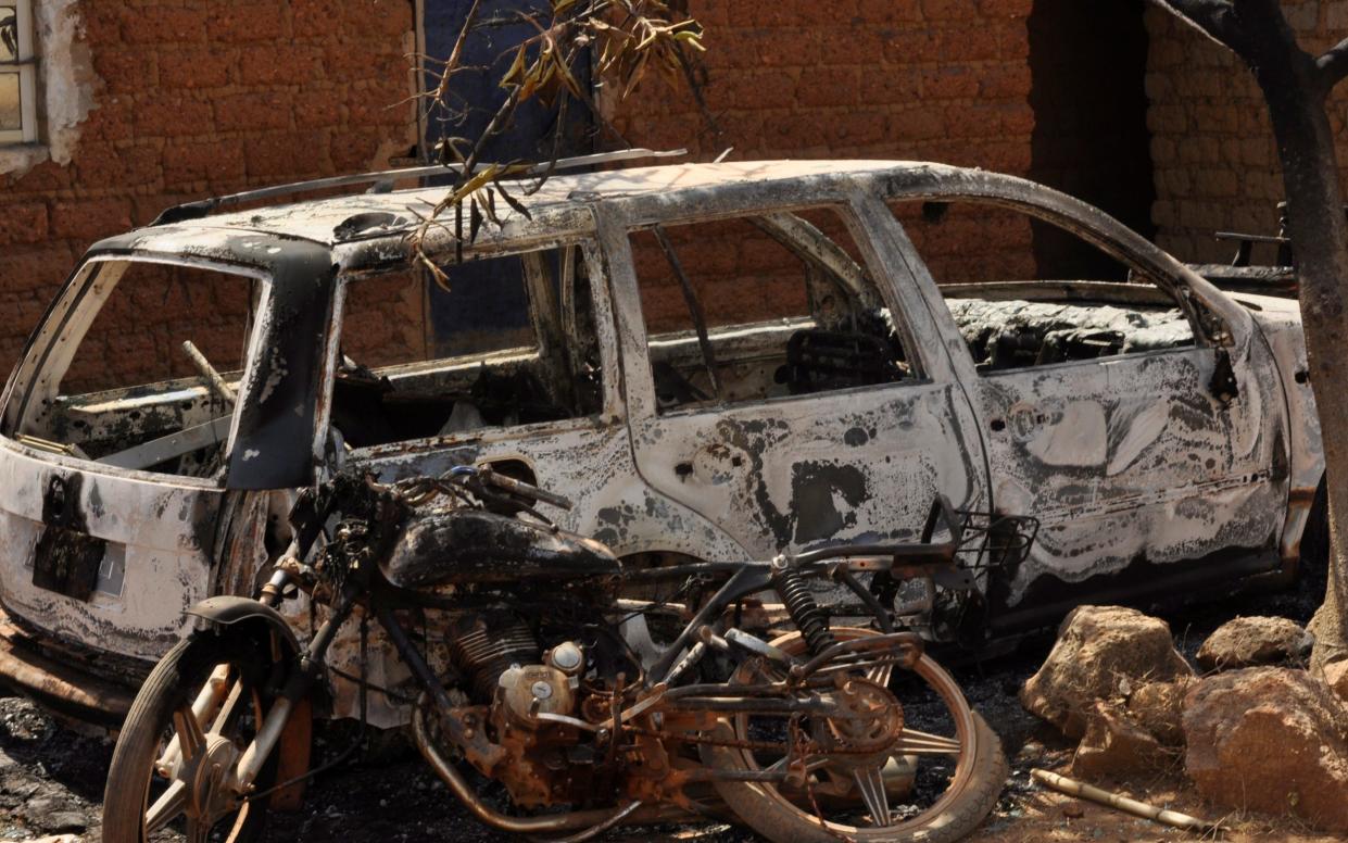 A burnt out car and a motorcycle is seen following an attacked by gunmen in Bokkos, north central Nigeria
