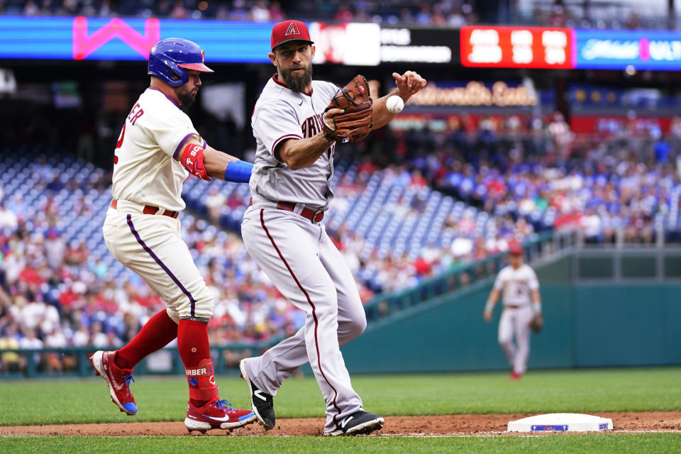 Philadelphia Phillies' Kyle Schwarber, left, collides with Arizona Diamondbacks pitcher Madison Bumgarner as he runs to first base on a single during the fifth inning of a baseball game, Saturday, June 11, 2022, in Philadelphia. (AP Photo/Matt Slocum)