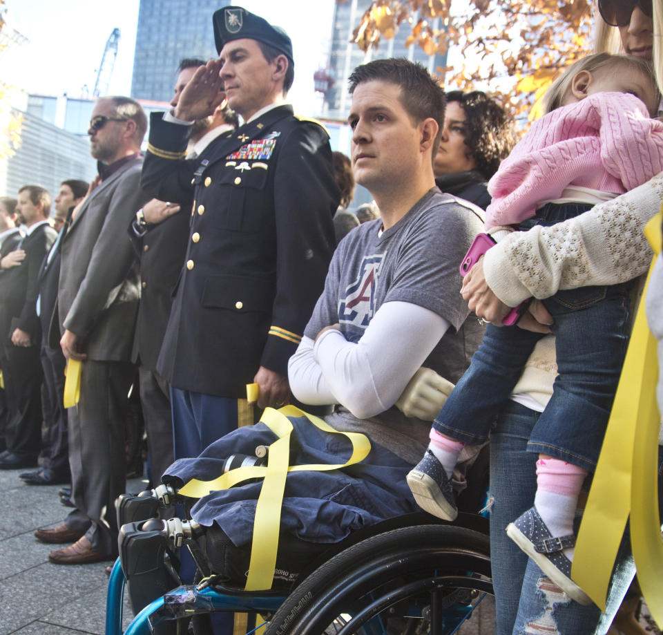 Brian Kolfage, al centro en silla de ruedas, durante un servicio que honró a los veteranos en Nueva York en 2014.  (AP Photo/Bebeto Matthews)