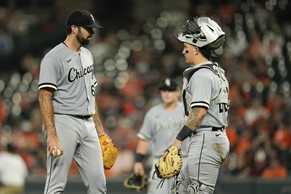 Chicago White Sox starting pitcher Jesse Scholtens, left, talks to catcher Korey Lee moments before being pulled out for a reliever against the Baltimore Orioles during the sixth inning of a baseball game, Tuesday, Aug. 29, 2023, in Baltimore. (AP Photo/Julio Cortez)