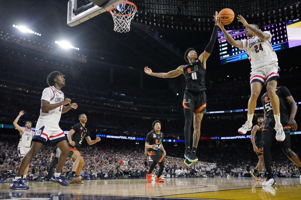 Connecticut guard Jordan Hawkins shoots over Miami guard Jordan Miller during the first half of a Final Four college basketball game in the NCAA Tournament on Saturday, April 1, 2023, in Houston. (AP Photo/Brynn Anderson)